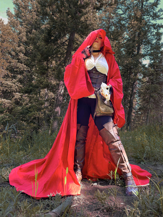 model in red full cloak holding a skull