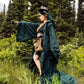 model wearing green robe and horns in forest